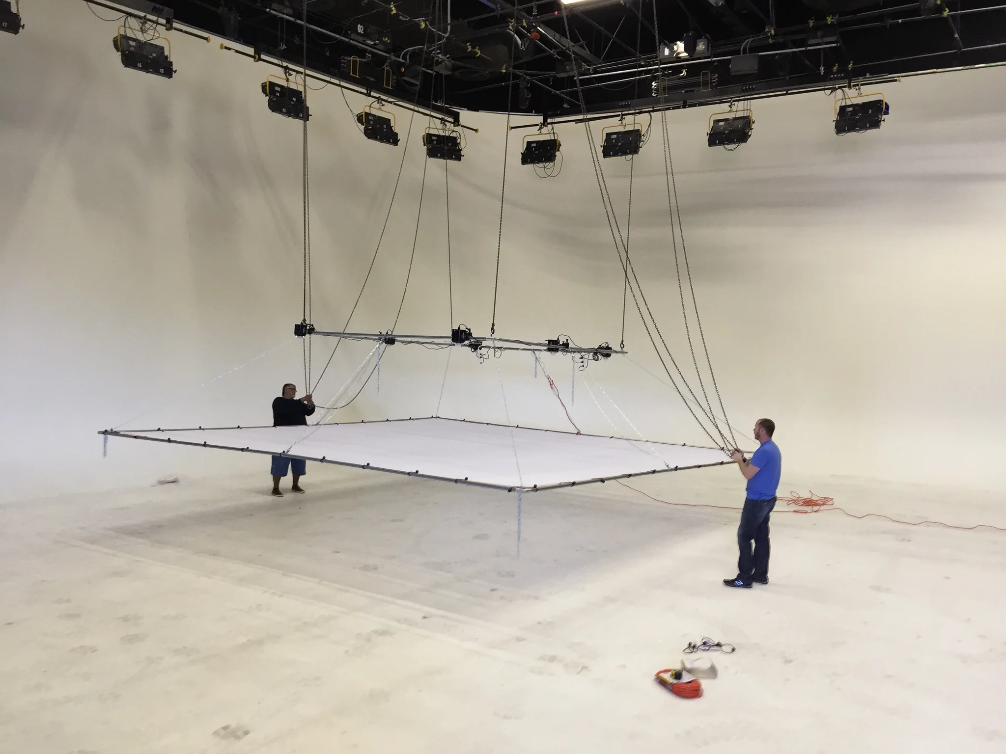 We have liftoff! 20' x 20' silk panel installed using 48 ball-bungees. Raising the rig requires four separate chains to be pulled simultaneously.