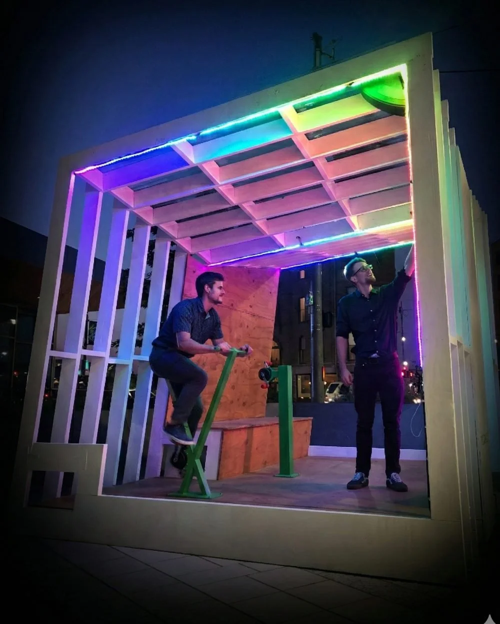 People pedalling bicycles to power a colourful light installation built by Electric Pedals