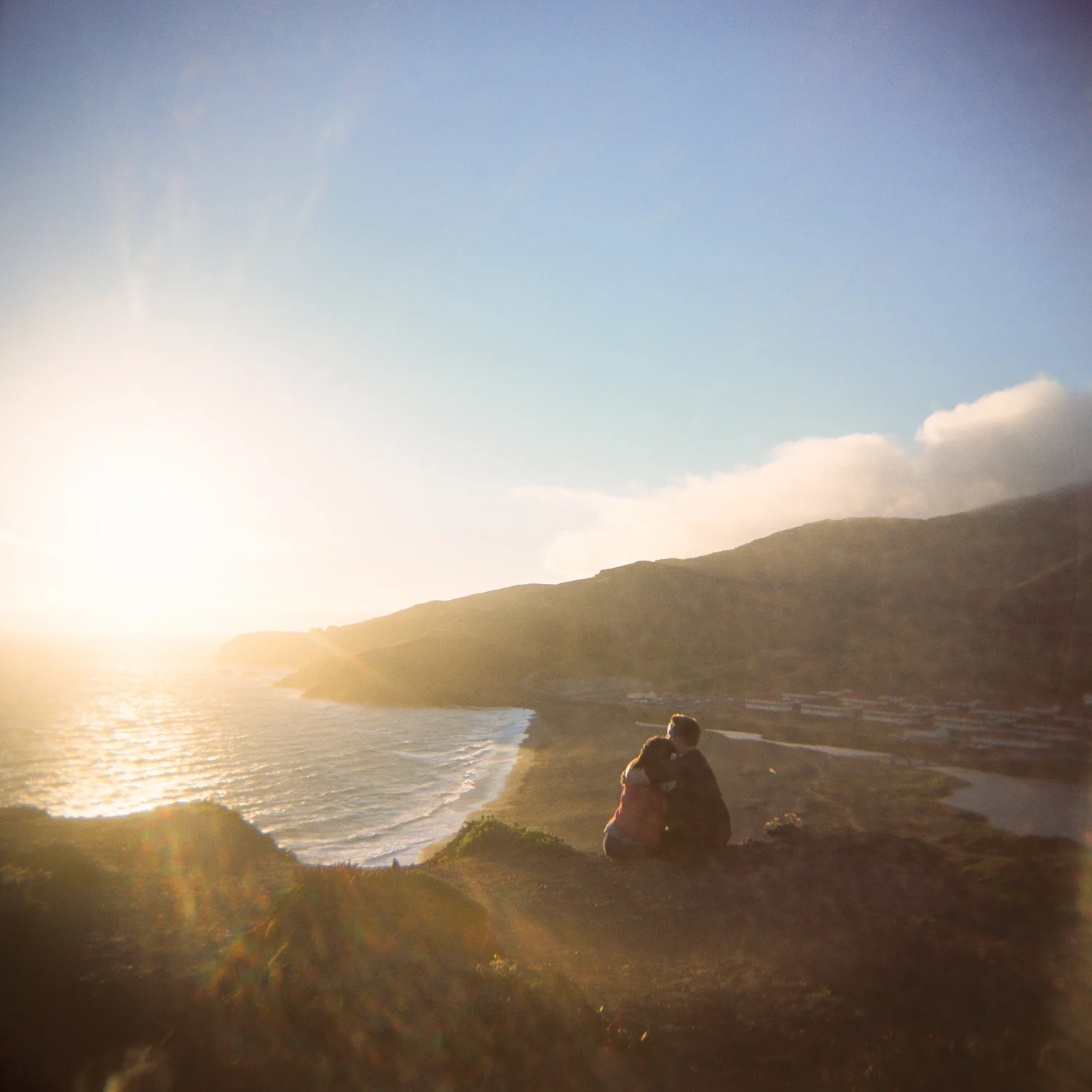 couple watches the sunset over the Rodeo Lagoon in Marin