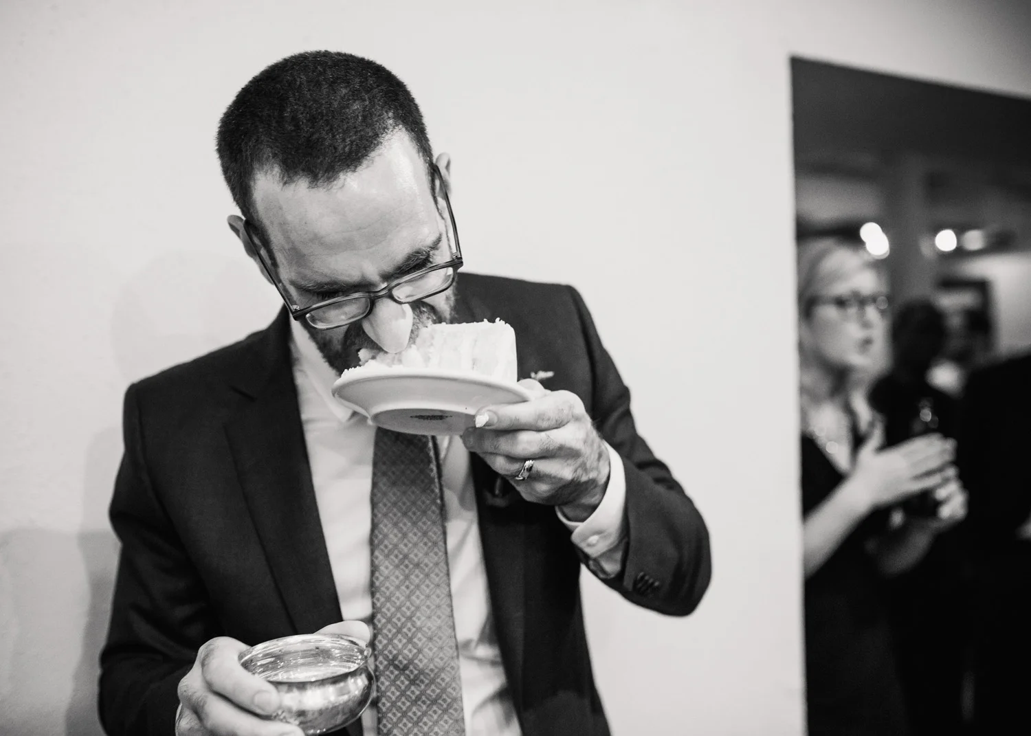 Groom eats cake without a fork after the ceremonial cake feeding