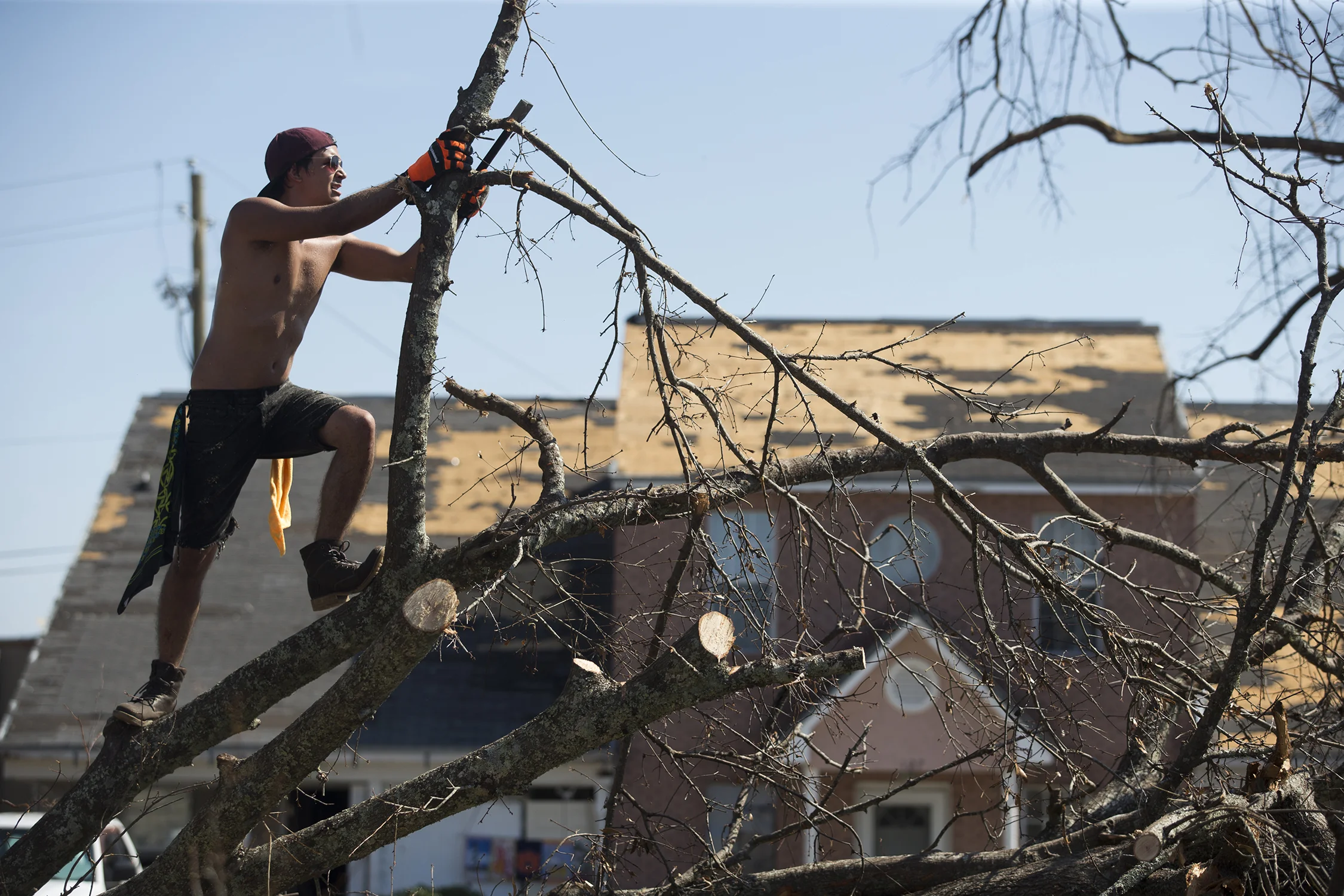  Tyler Gay cuts up two trees knocked over by Hurricane Michael in Parker, Florida on Friday, October 19, 2018. Multiple residents on the street made requests on thechainsawarmy.com for help in removing the trees blocking in cars and the road. He uses