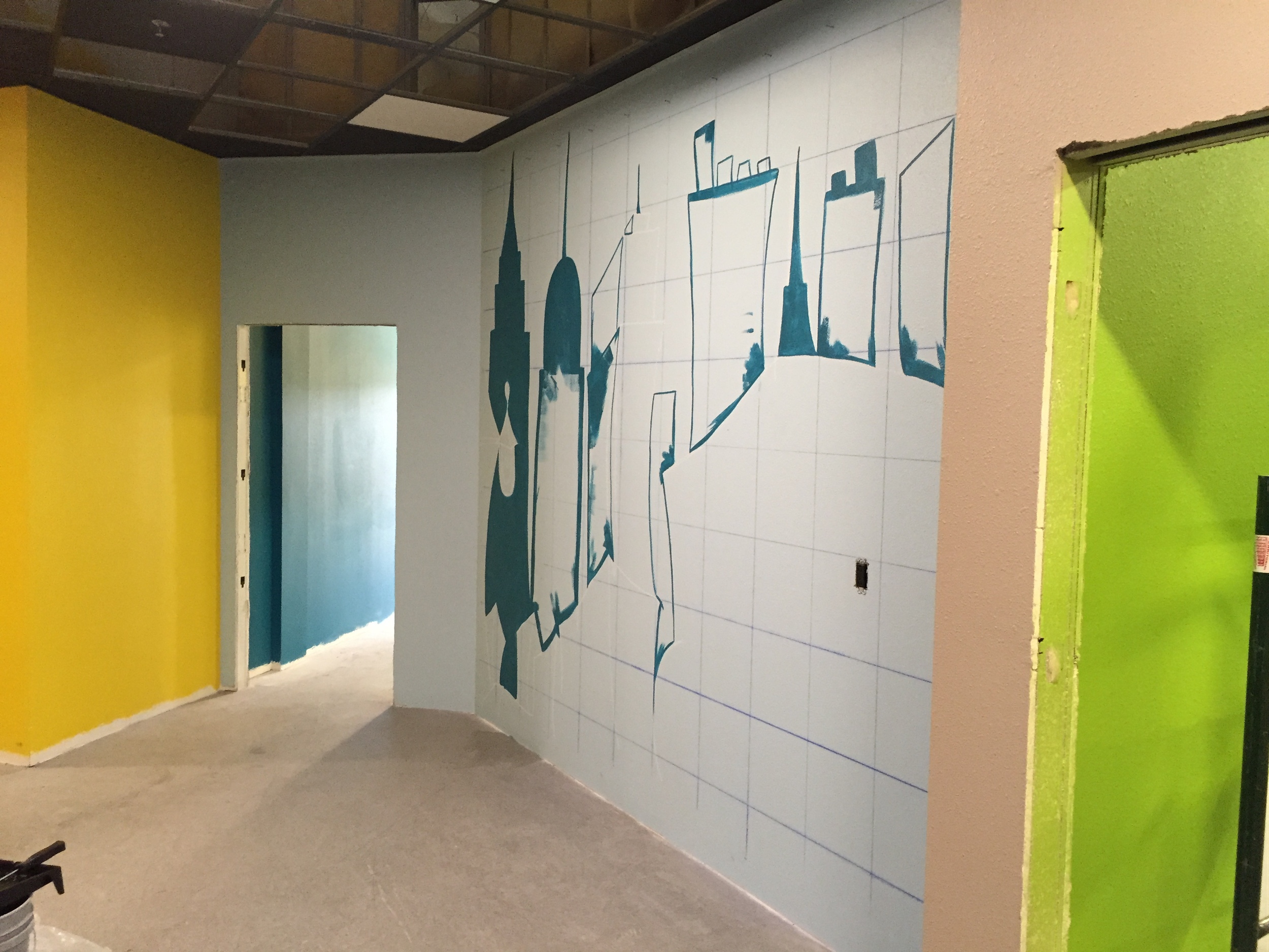 The beginnings of the mural in the Kids' City check-in area.