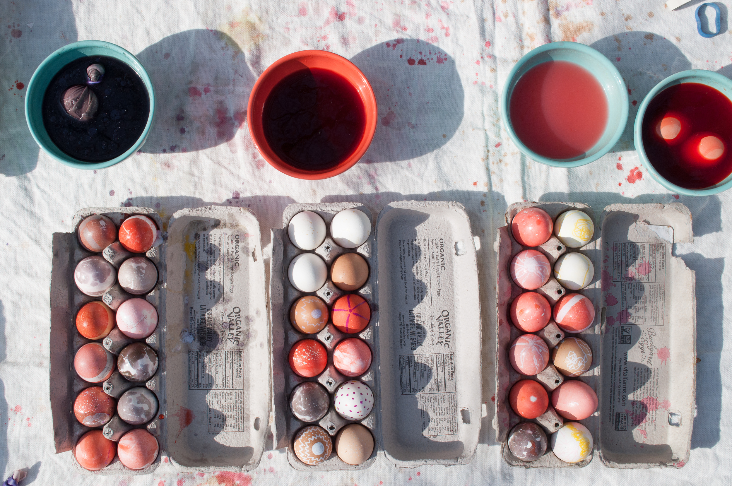 My girls were in the market for more of a quick fix and although factory farmed conventional eggs and kool-aid aren't exactly things I have any desire to support, sometimes I bend a little. Paint pens from the local art store and kool-aid mixed with oil helped us create pretty dreamy marbleized and patterned eggs. We also experimented with collecting leaves and blooms from around the neighborhood, pressing them to our eggs, then wrapping and securing old stocking around the egg to hold the plant matter in place. These eggs were dunked in kool-aid and when peeled apart created cool shadow prints!