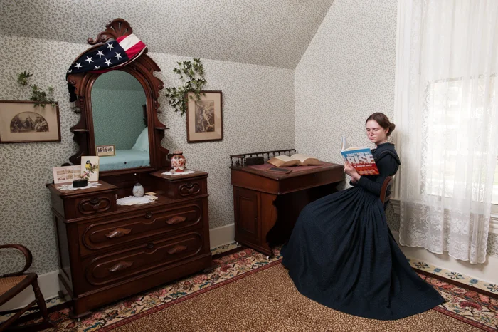 A Room of One's Own. There are several archival images of Willard surrounded by libraries worth of books, stacked and shelved about her, papers in piles and photographs tacked around her work space. She was an avid reader, consumer of information, thinker and writer. This image imagines a young Frances in her bedroom in a quest for knowledge about the future. She is preparing for a lifetime committed to the labor of empowering women young and old across the boundaries of race, class and nationality. Reading text after text she has settled in with Together We Rise: The Women’s March Behind the Scenes At The Protest Heard Around The World, in order to gather wisdom about what is important to women of the future so that she might better shape her efforts. Perhaps she had a certain psychic clairvoyance that allowed her to borrow pre-release texts, a sort of free library with the future. Willard was known for reading late into the night and taking notes on her slate to inform her later writing. 