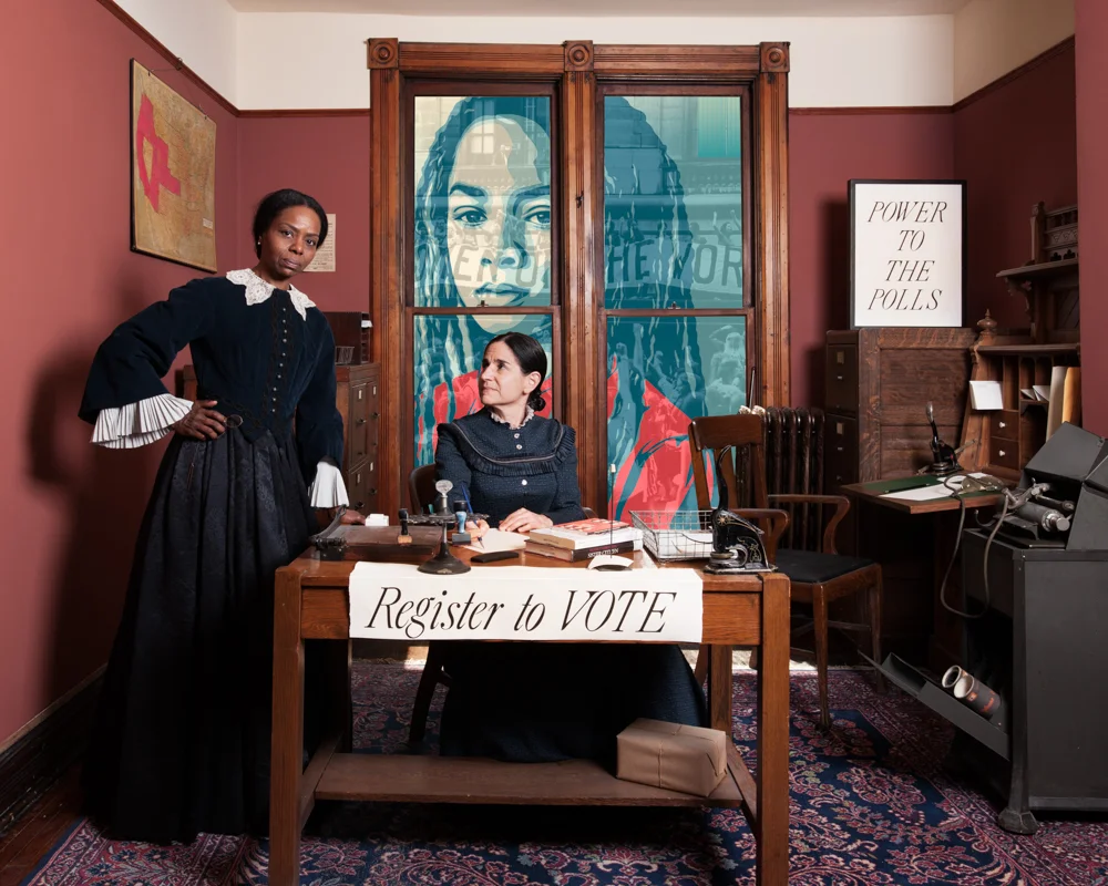 Power to the Polls. Power to the Polls depicts Frances Harper, an African-American abolitionist, suffragist, poet and author who was head of her local WCTU chapter in Philidelphia and Catherine Waugh McCullloh a lawyer, suffragist and member of the WCTU who was one of 100 female attorneys in the country in the 1890’s and would go on to become the first female Justice of the Peace in Illinois and first female presidential elector. Both women committed much of their lives to the cause of women’s suffrage and were instrumental in achieving the vote for women. This image imagines a moment of both confidence and power, where Harper and McCulloch are partnered in their pursuit of strategizing over the next steps in the fight to obtain the right for women to vote. The image is also a celebration and encouragement for us today to embrace our right and responsibility to vote, and speaks to the history of the power of voting. The present day Women’s March platform kicked off a Power to the Polls campaign in January 2018 to register voters, engage impacted communities and harness the collective energy to advocate for policies and candidates that reflect our values and the election of more women and progressive candidates to office. Similarly the women of the WCTU worked tirelessly to have their voices represented and to push congress toward more progressive legislation despite not initially having the vote. On the wall to the left of Harper is a map of the US in 1911 marking the states that had suffrage and those that were on the brink of suffrage. In 1913 Illinois gained suffrage for women and in 1920 women’s suffrage was officially adopted by the nation, although discrimination and denial of the right to vote persists in insidious ways even after the success of the 1965 Voting Rights Act prohibiting racial discrimination in voting. Layered into the image as well is one of the posters Shepherd Fairey designed for the Women’s March of 2017 that has a tag line, not shown, We The People Protect Each Other. Underlying this image is an image from the August 26, 1970 Women’s Equality March where 50,000 people marched in the streets of New York city to celebrate the 50th anniversary of the nineteenth amendment. The many parts of this image are combined to create a historical narrative of the past reaching toward the future. (It is noteworthy to mention that the woman depicting Catherine Waugh McCulloch is actually her grand-daughter, so a very direct descendent from this particular moment in history and that national and international meeting of the WCTU were not segregated, but that local chapters of the WCTU often met in and through their churches and were segregated. Harper visited the national WCTU headquarters at Rest Cottage and would have met and worked with other black and white women who were in the house at the time.)