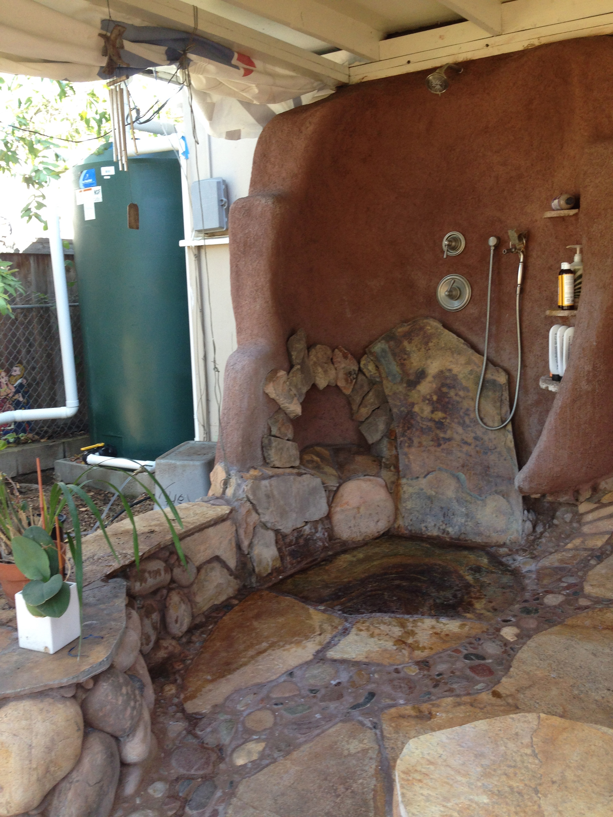 This outdoor shower came into being after deciding that getting to the piping in the slab was too cumbersome. Investing in a beautiful shower space where the water drains right to the garden proved a better investment!
