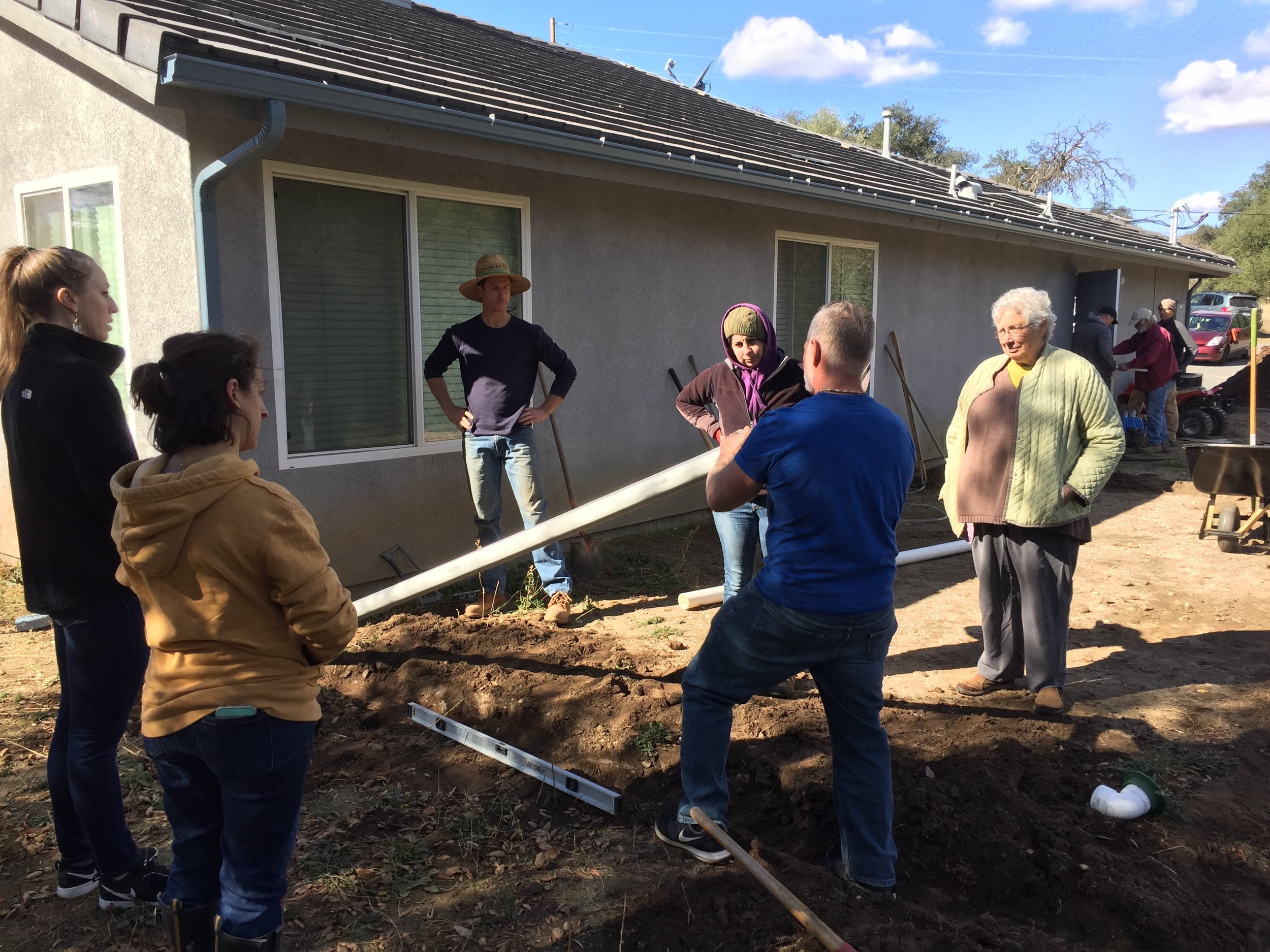 Working together to reroute rainwater downspout into laundry greywater basin