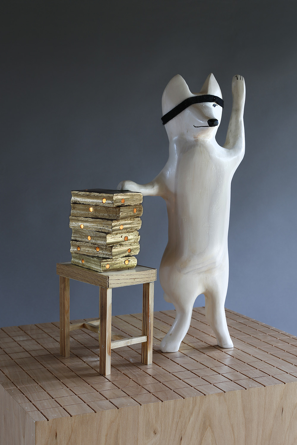 "Fox Swearing on a Stack of Holey Books", 62" h x 21" w x 18" d; wood, stain, plexiglass, gold leaf, felt, LED light; © Tom Gormally 2019