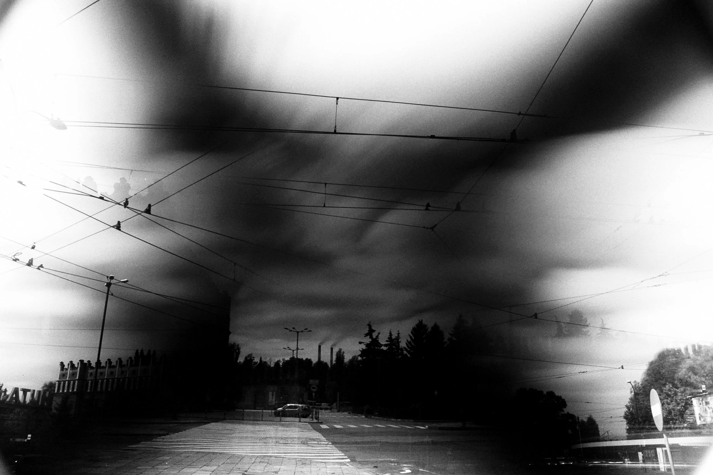 Nowa Huta, former Soviet era Steel Works and Town. Triple exposure, facing opposite ways. Different timings, ND and wide for the clouds, hence the unusual 'x' pattern and regular exposure for the car/ crossing section. And 1 bonus exposure for the tram station bottom right.