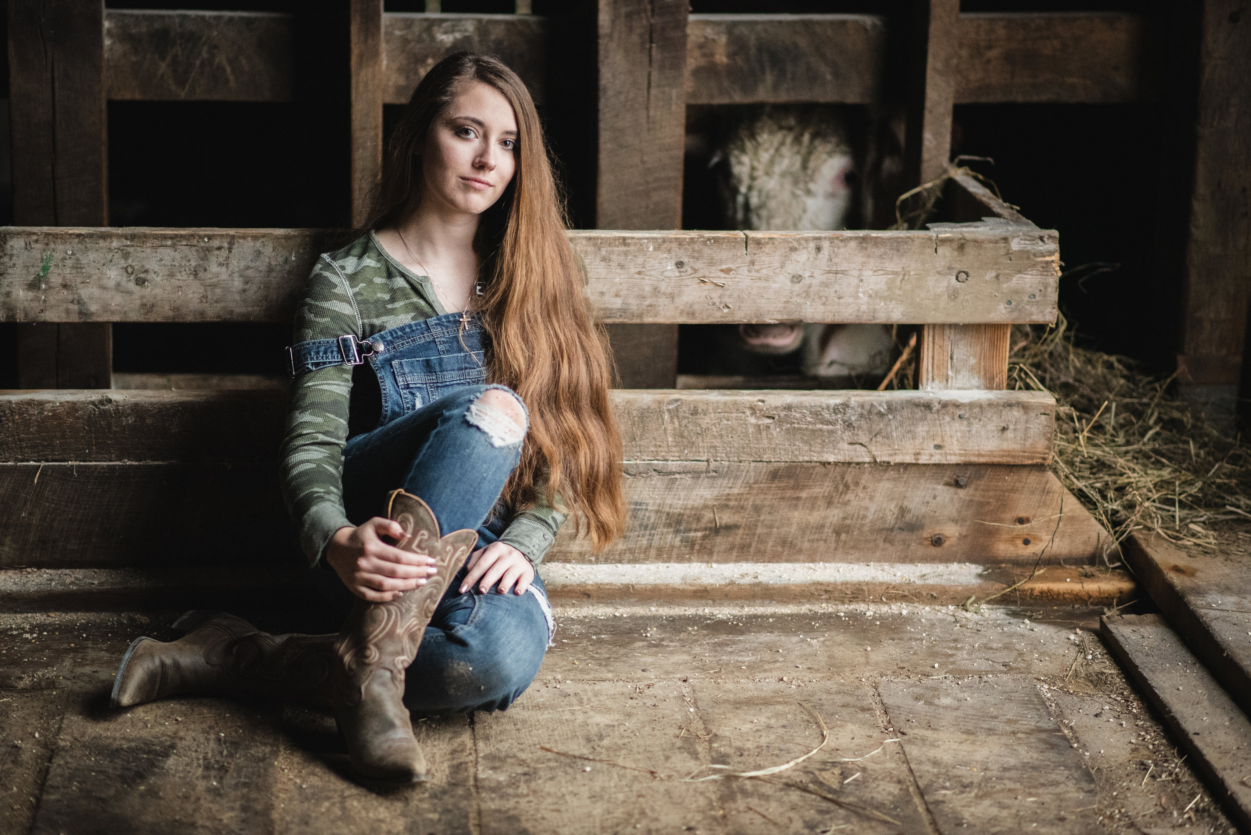 Girl in front of a moo cow with long hair.