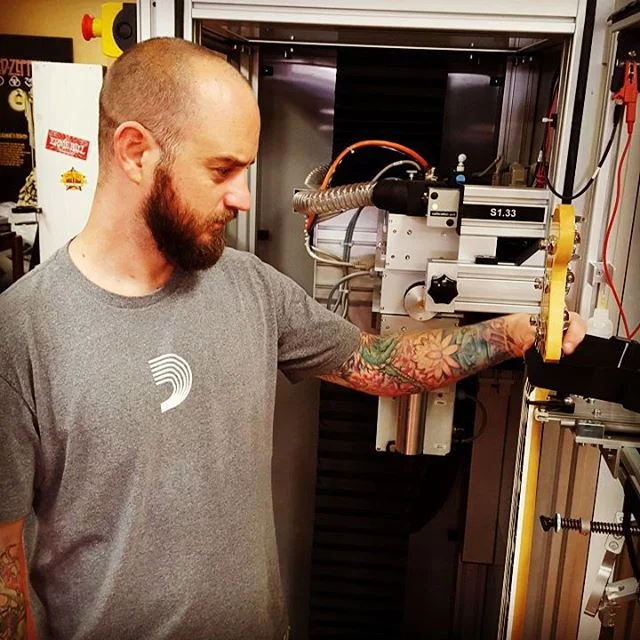 Strapping an instrument into the Plek Station for fret dressing and setup