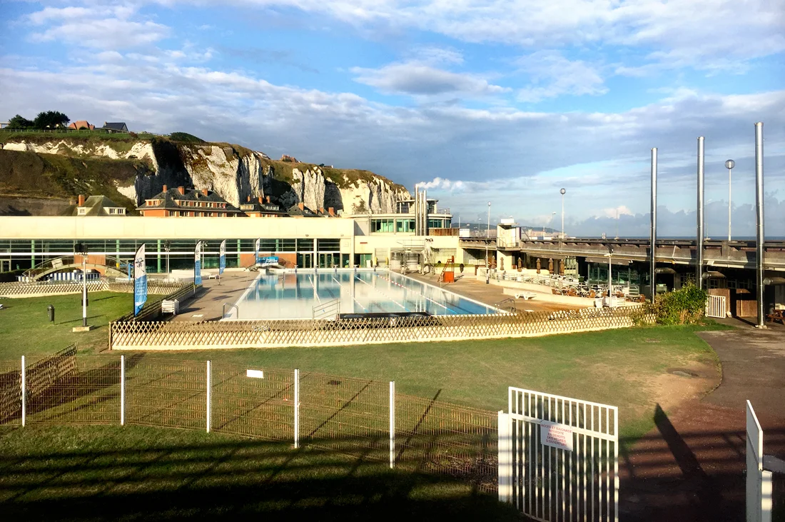 Dieppe, France. Public s wimming pool in the early morning sun, with on the background the famous chalk rocks.