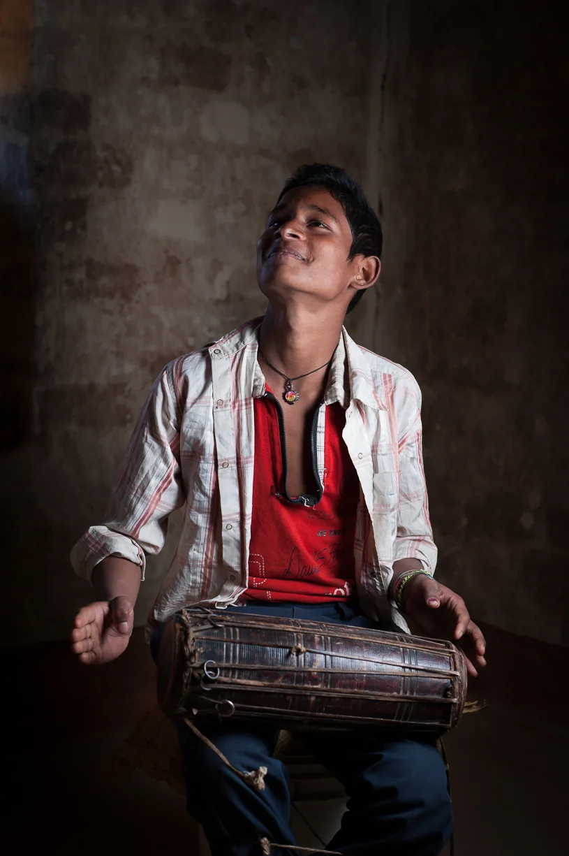 This is his son who is carrying on the Gandharba tradition by playing the drum. I knew I wanted to photograph him because he lights up while performing. Most Gandharba children are not learning to play instruments anymore.
