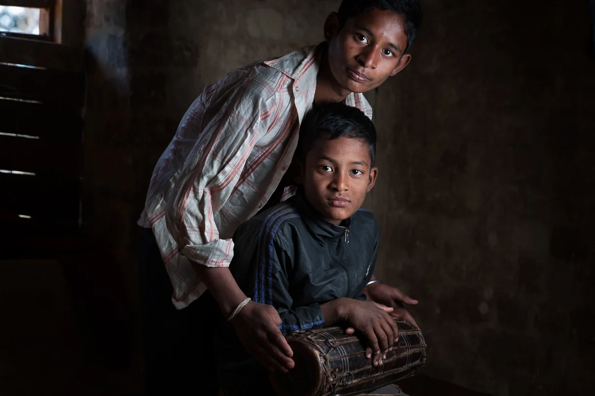 This younger brother doesn't play an instrument and doesn't attend school. 