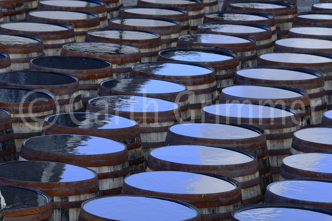 Sky reflected in rain on top of scotch whisky barrels