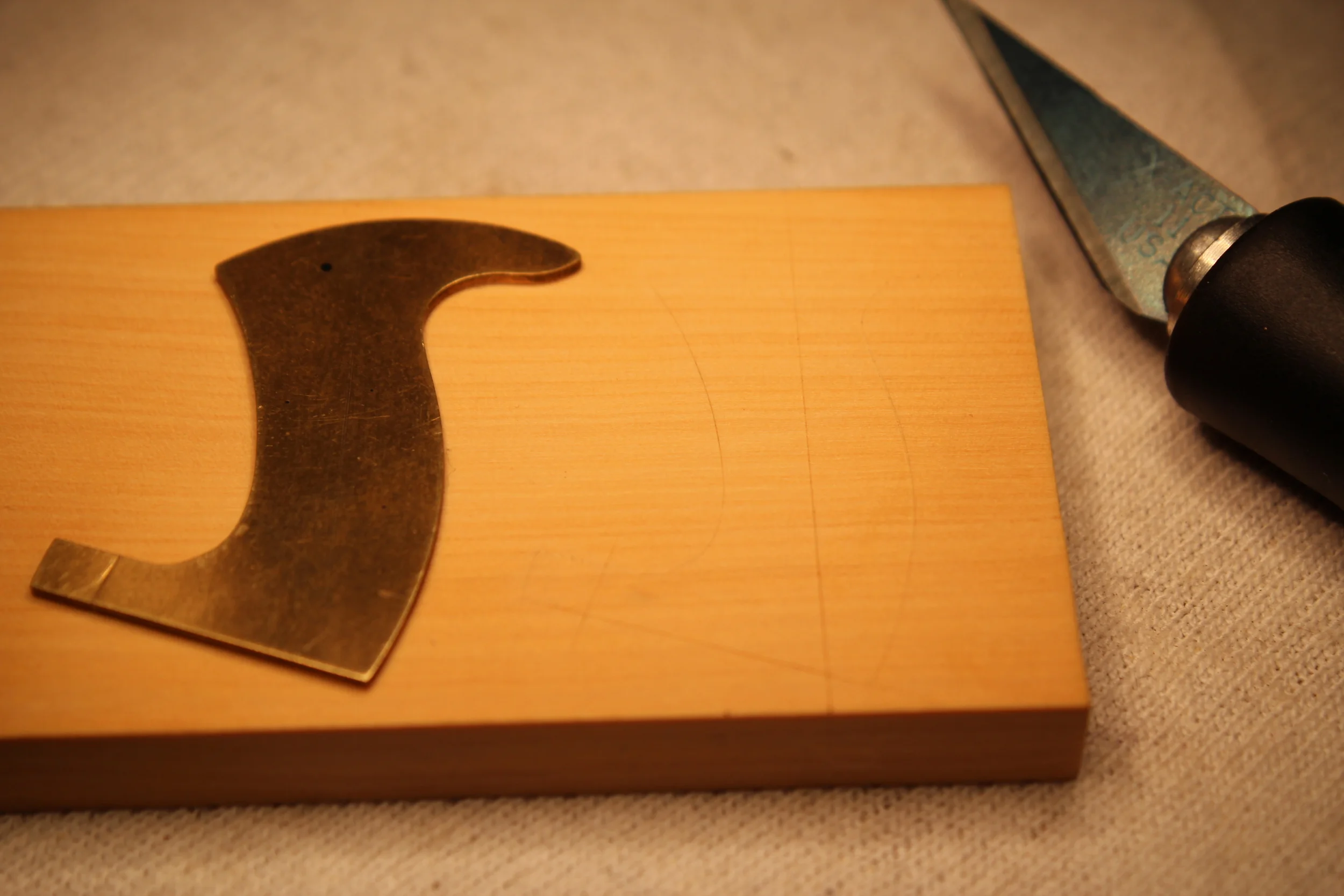 The tote shape transferred to the wood. See the center line for the front hole?