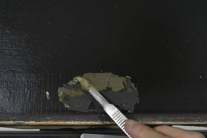This is a detail shot of the mechanical removal of the varnish layer. 