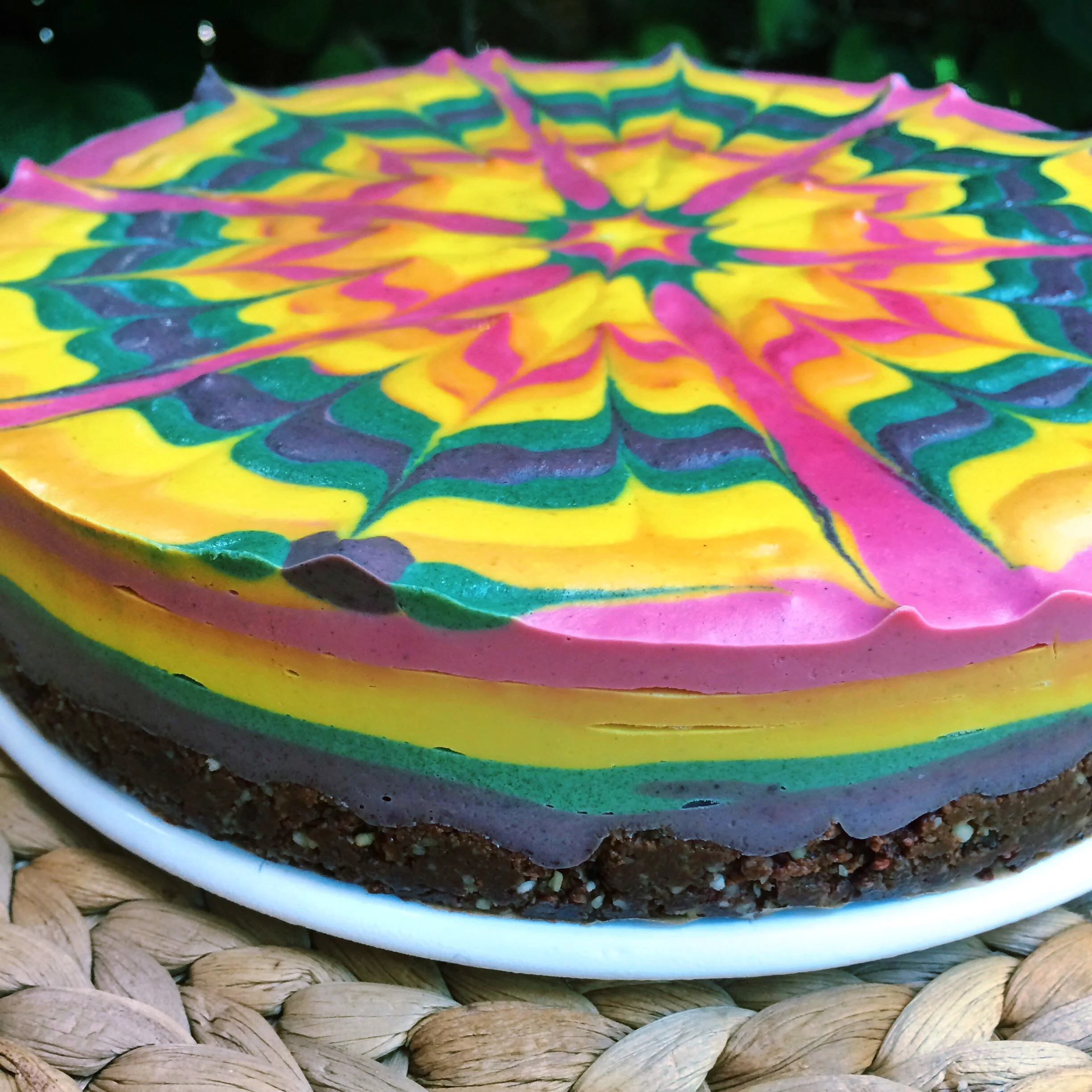 Detail of Stephen's rainbow raw vegan cheesecake made of beet, turmeric, spirulina, and blueberry!