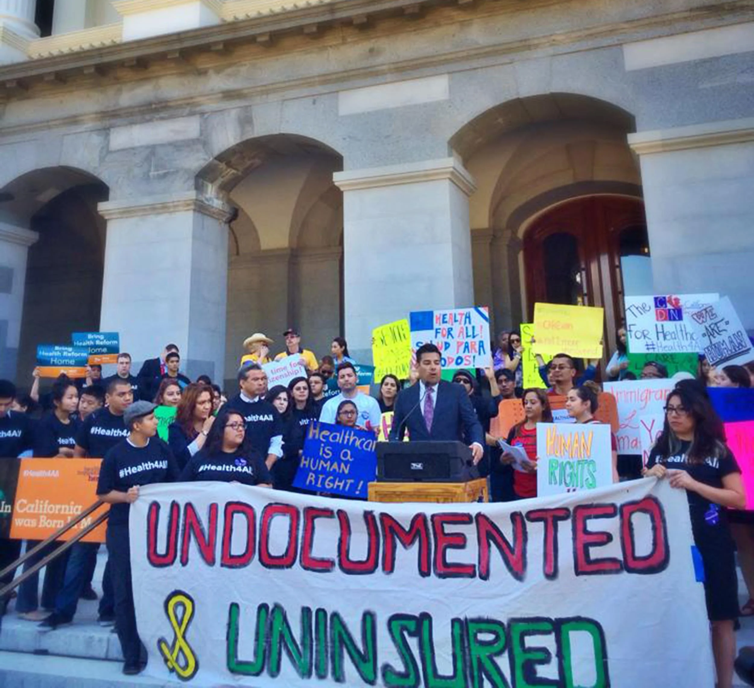 Why should we care about providing access to health insurance for immigrants? 