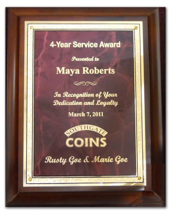 Southgate Coins owners Rusty and Marie Goe honor Maya Roberts on her 4-year anniversary with the coin shop