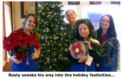 Southgate Coins owner Rusty Goe sneaks into the picture of the girls decorating the Christmas tree.