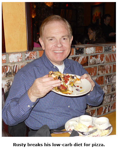 Southgate Coins owner Rusty Goe enjoys his low-carb pizza during the holiday get-together