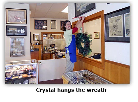 Crystal hangs a wreath at the coin shop