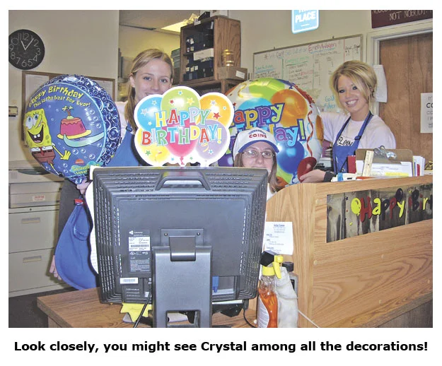 Southgate Coins employee Crystal hides among the birthday decorations at her desk