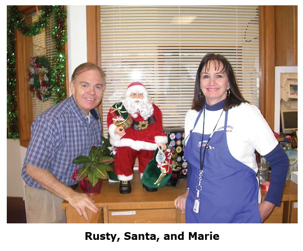 Southgate Coins owners Rusty & Marie Goe pose with a mini Santa