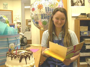 Maya is jazzed to read her birthday card at the Coin shop
