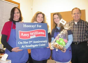 Southgate Coins owners Rusty and Marie Goe present Amy with an achievement sign on her anniversary