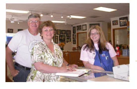 Southgate Coins employee Amy presents her parents with an autographed copy of Rusty’s James Crawford book