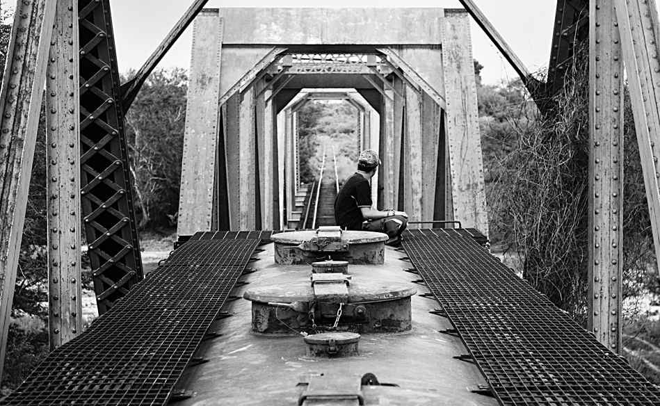  An unaccompanied minor travels on the last wagon of the train. Each year thousands of unaccompanied minors leave their countries fleeing violence and migrate to the United States.   Ciudad Ixtepec, Oaxaca, Mexico.   2008     