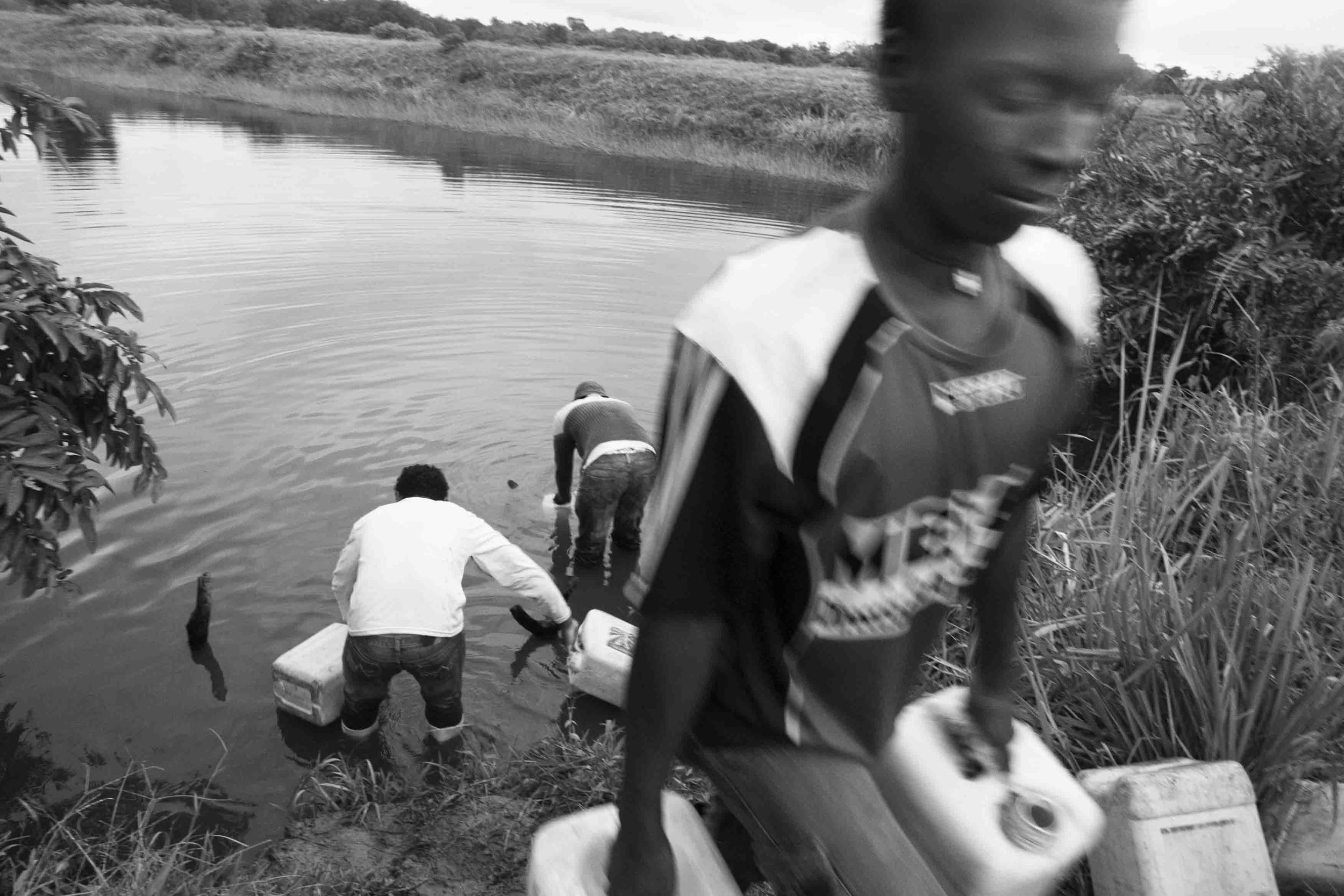  The life of the communities inside the Cayapas Mataje Mangrove Reserve is harsh due to a constant shortage of water. In the picture kids fetch water from a source in a private farm outside the Reserve. Tambillo, Ecuador. 2010. 