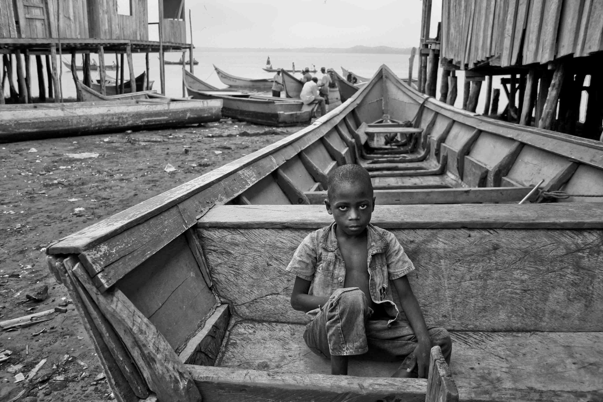  A child sitting on a boat looks at the camera. Pampanal de Bolívar, Ecuador. 2010. 
