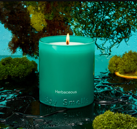 A scented candle from Boy Smells featuring a lush, wet green and blue aesthetic.