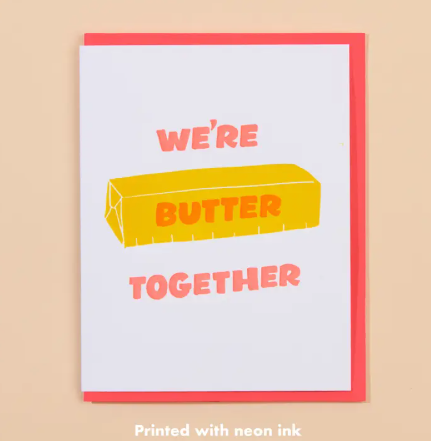Spread joy and laughter with the letterpress Butter Together greeting card by And Here We Are, featuring a cheerful yellow stick of butter and vibrant neon pink typography.