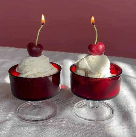 Celebrate with a pair of realistic Dark Red Cherry Beeswax Birthday Candles by Happy Organics lit on top of two scoops of vanilla ice cream in glass bowls.