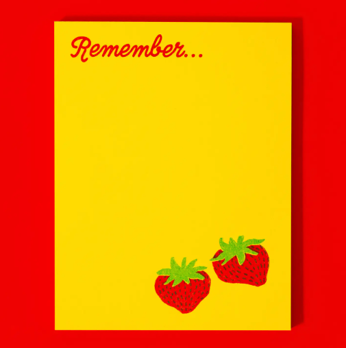 A notepad with two strawberries at the bottom of a yellow page.