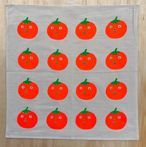 A classic and charming hand-printed cotton tea towel with a bold tomato design, ideal for a rustic or modern kitchen.