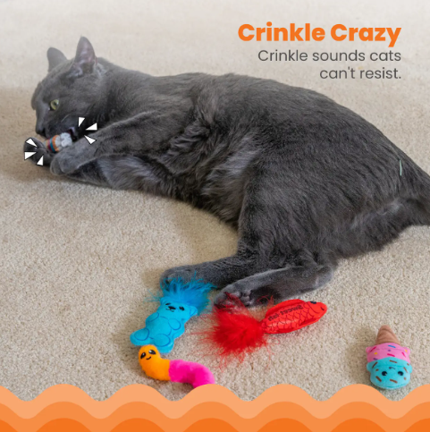 A grey cat lying on a carpet playing with a small plush toy from the Kitty Sweet Treats collection.