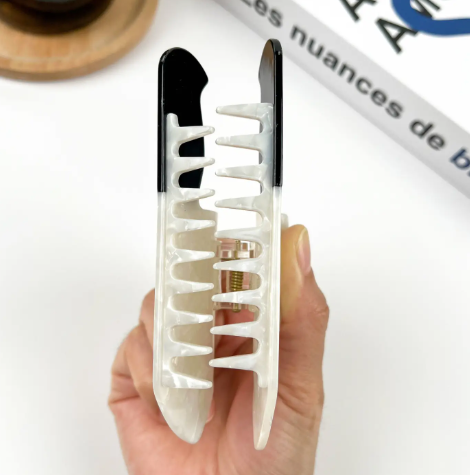 A durable 4.7-inch acetate hair claw with a strong grip, designed in a playful and sharp knife silhouette.