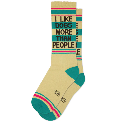 A pair of light khaki ribbed athletic socks with the words "I LIKE DOGS MORE THAN PEOPLE" in bold black lettering, along with fuchsia and teal stripes.