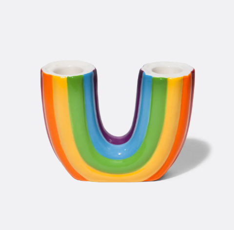 The U-shaped ceramic rainbow candle holder, showcasing its glossy, multicolored design and double candle openings.