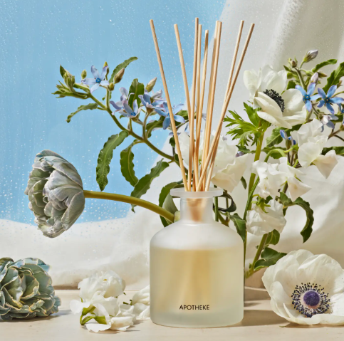 Luxury home fragrance diffuser from APOTHEKE with a minimalist matte-finished glass base and a bundle of ten-inch scent sticks.