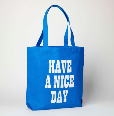 The reverse side of the blue canvas tote bag, featuring the bold white text "HAVE A NICE DAY" in a vintage-inspired block typeface.