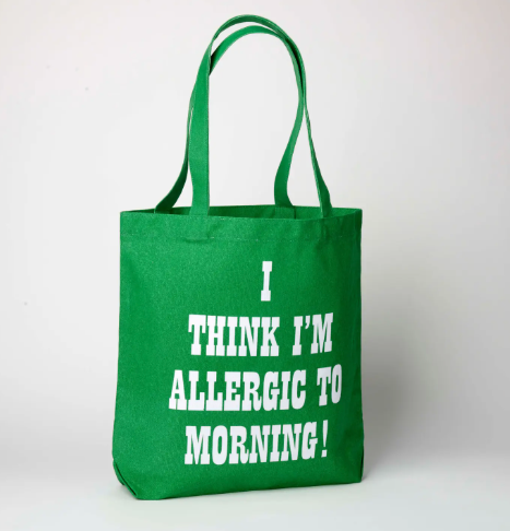 The reverse side of the green canvas tote bag, featuring the bold white text "I THINK I'M ALLERGIC TO MORNING!"