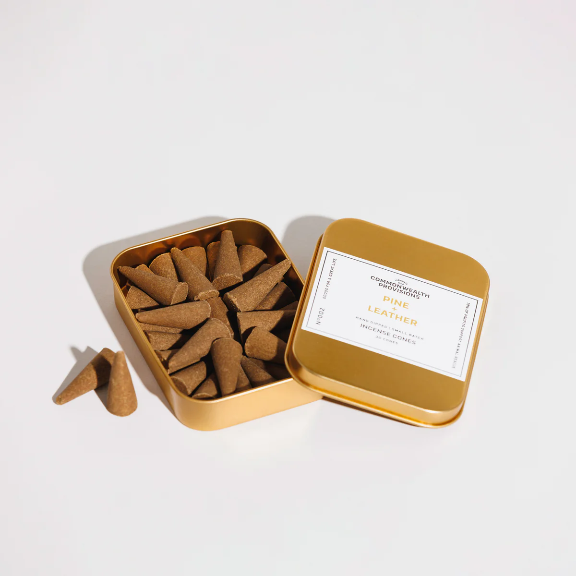 Pine + Leather Incense Cones by Commonwealth Provisions: The tin packaging displayed alongside the incense cones, perfect for bringing the outdoors into your space.