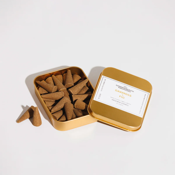 Oakmoss + Fig Incense Cones by Commonwealth Provisions: The tin packaging displayed alongside the incense cones, perfect for creating a grounding and uplifting atmosphere.