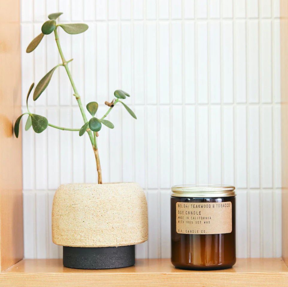 Elegant P.F. Candle Co. Teakwood & Tobacco Candle surrounded by sophisticated decor, enhancing the original and enduring atmosphere of the space.